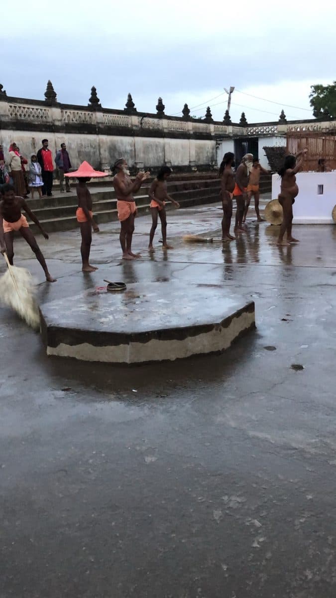 People moving across the wet courtyard around a circular platform.