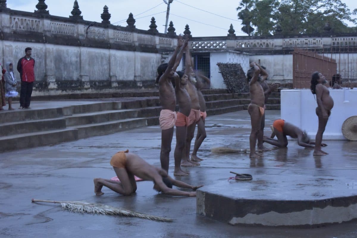 Several participants in different postures around a wet courtyard platform.